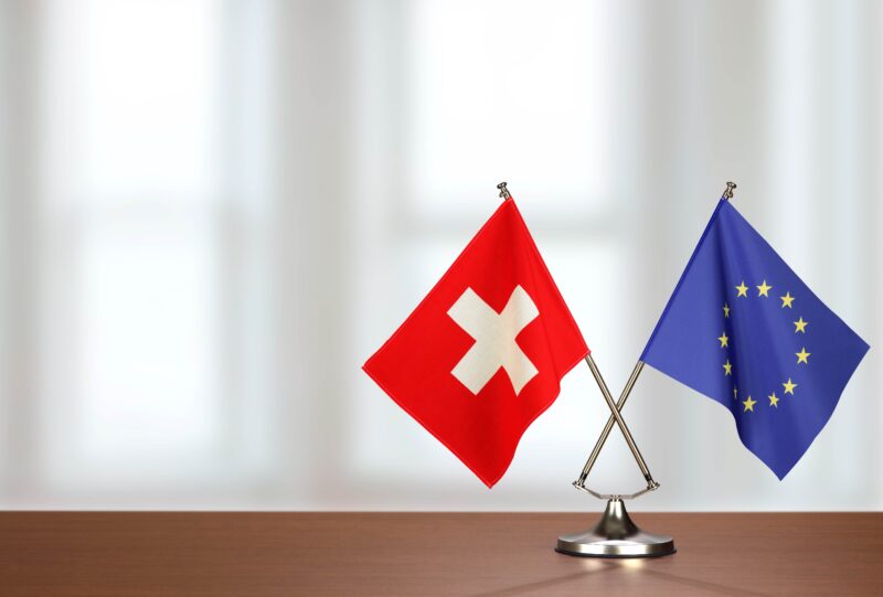 Schweizer Fahne und EU-Fahne auf einem Tisch
