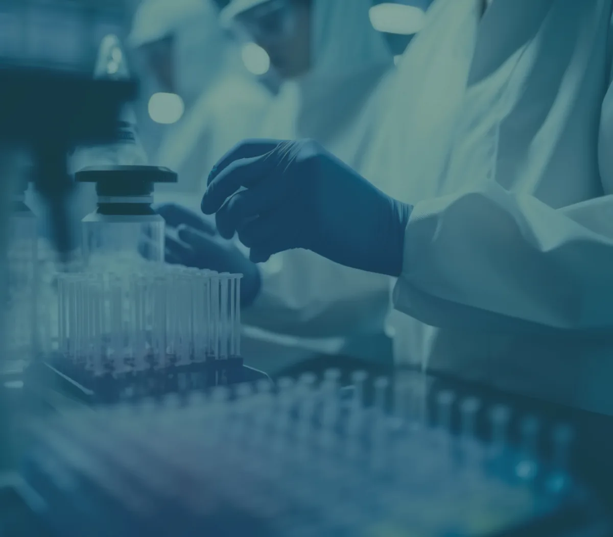 Hände mit Laborhandschuhen bei der Arbeit mit Probenfläschchen