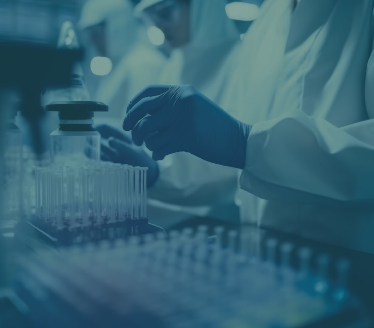Hände mit Laborhandschuhen bei der Arbeit mit Probenfläschchen